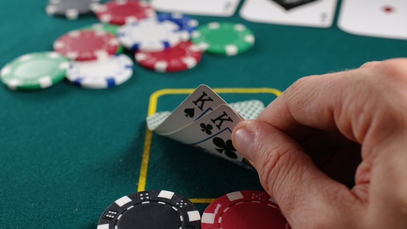 person holding white and black playing cards