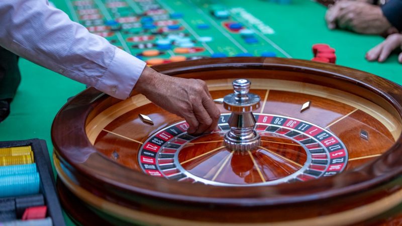 a man is playing a game of roule on a green table