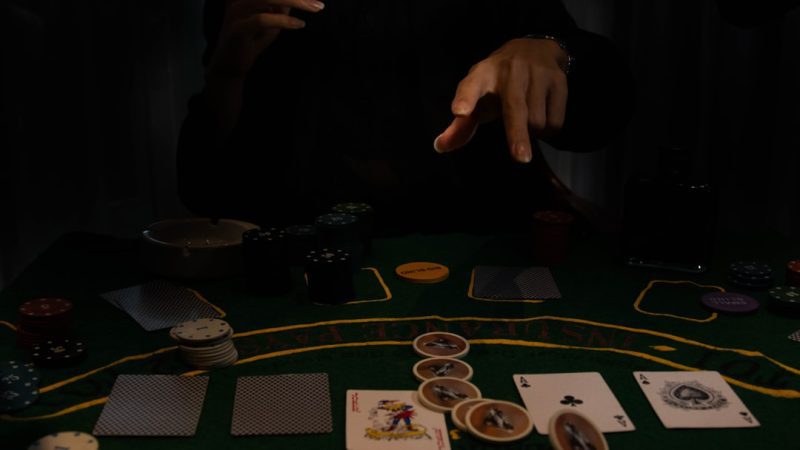 a person sitting at a table with cards and chips