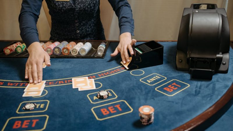 Casino dealer organizing cards and chips on a gaming table during a game.