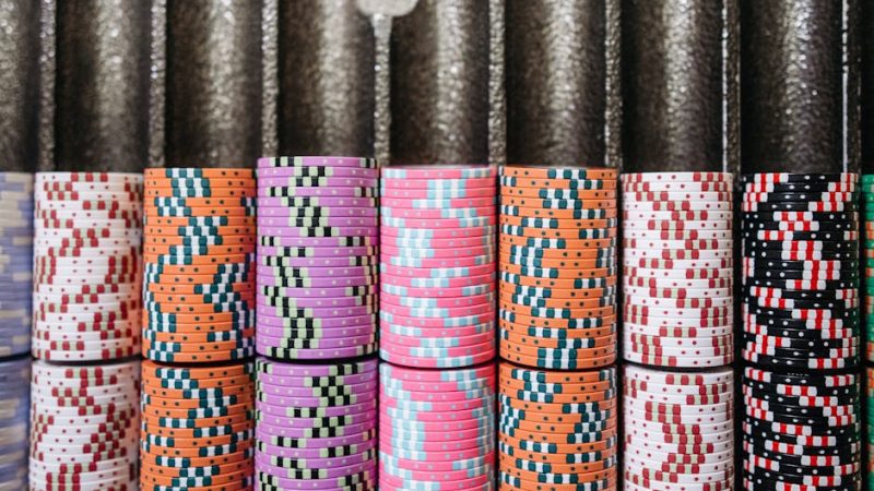 A close-up of colorful casino chips neatly stacked in rows, symbolizing the gambling experience.